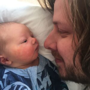 Dad laid with his baby face to face