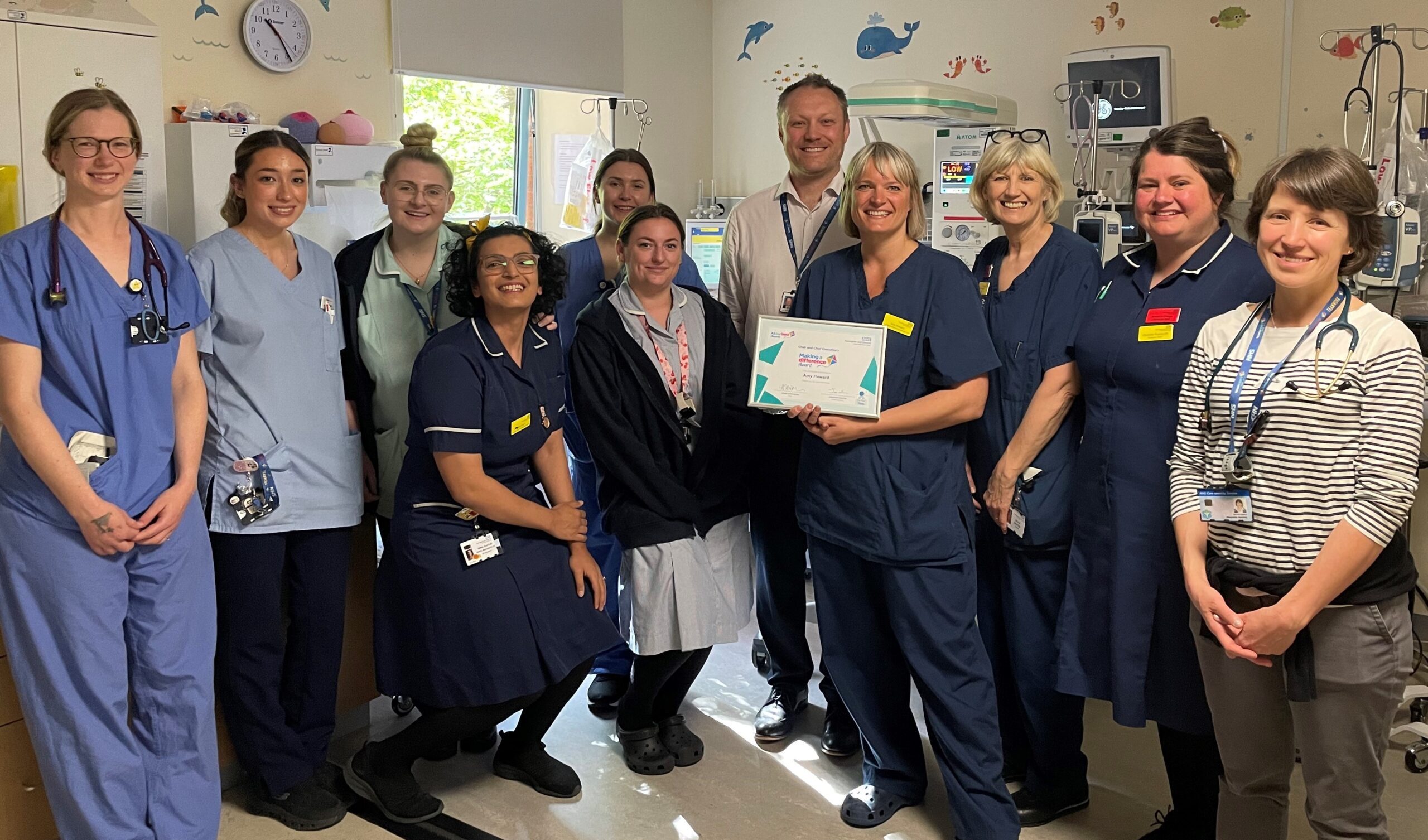 HDFT’s Making a Difference winner with colleagues receiving the award presented by a Trust Executive.